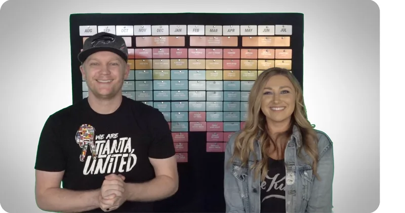 Kenny and Elle Campbell in front of a Grow year-long planning board